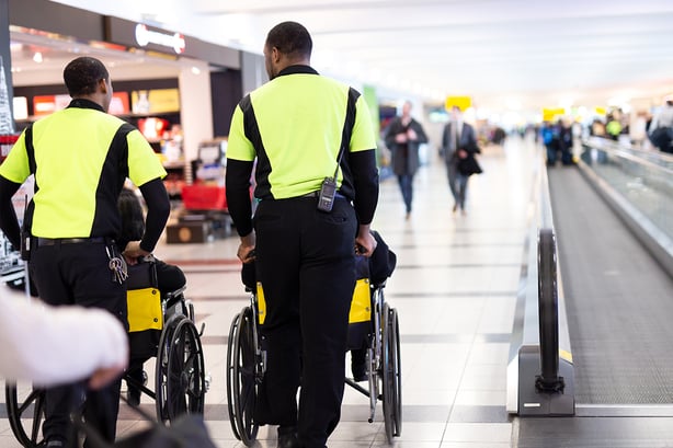 Aviation team members helping passengers in wheelchairs