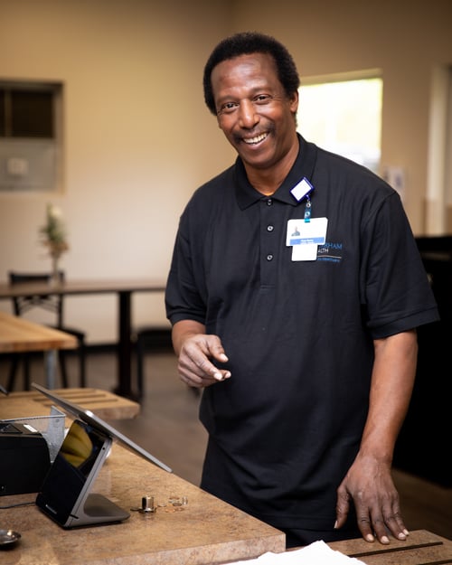Team member at register smiling
