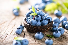 blueberries in basket on wood