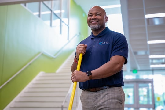 male janitor pushing broom