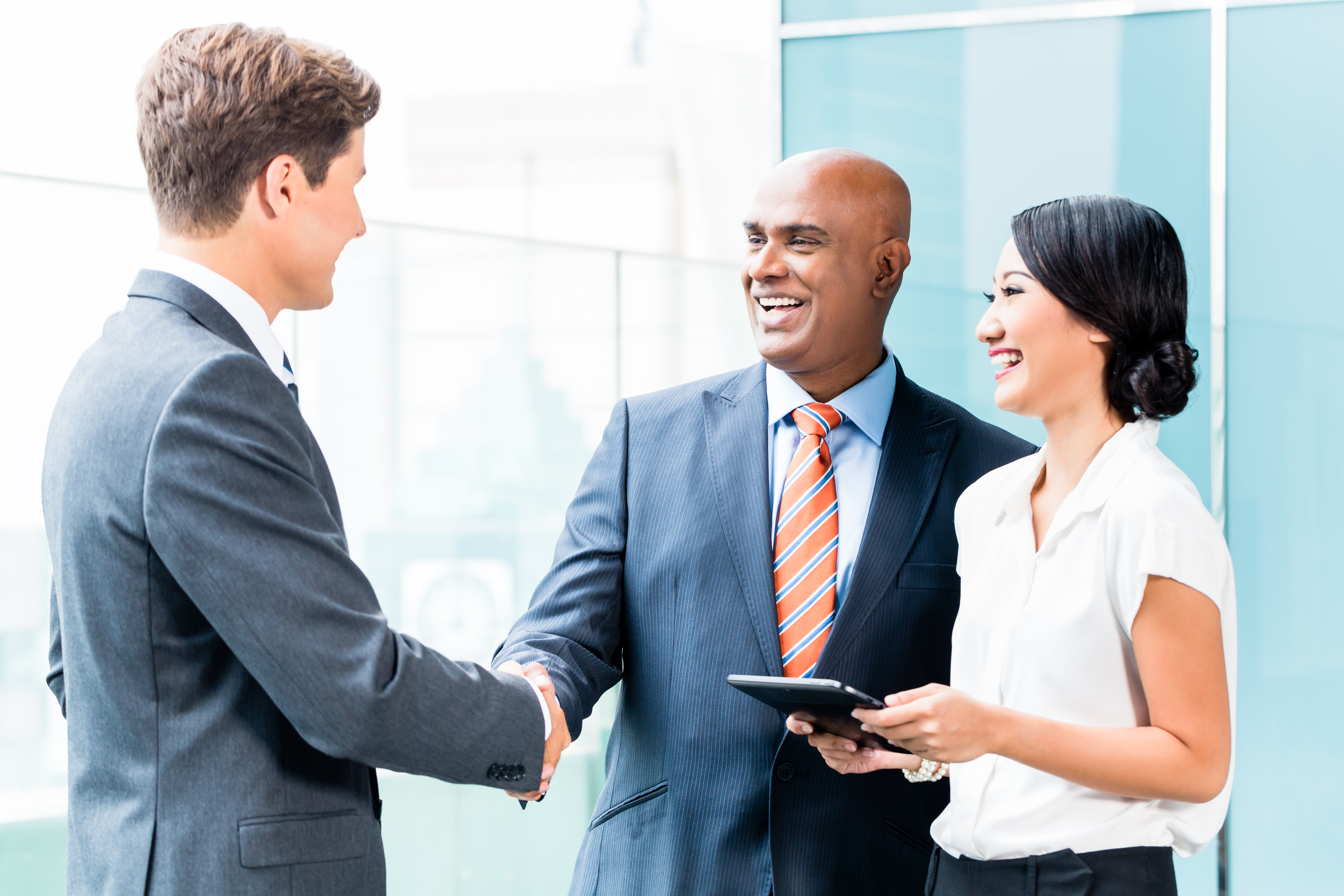 Salesman shakes hands with business leaders