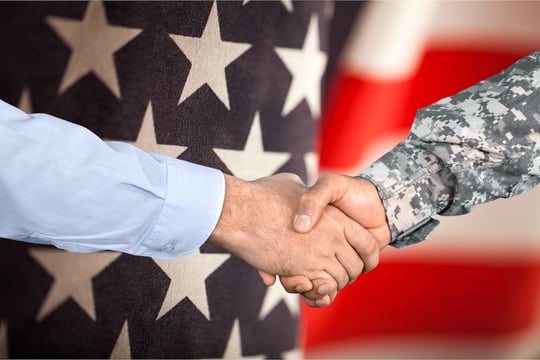 Close-up of a handshake between a civilian and a service member in uniform, symbolizing military-to-civilian career transition through SkillBridge