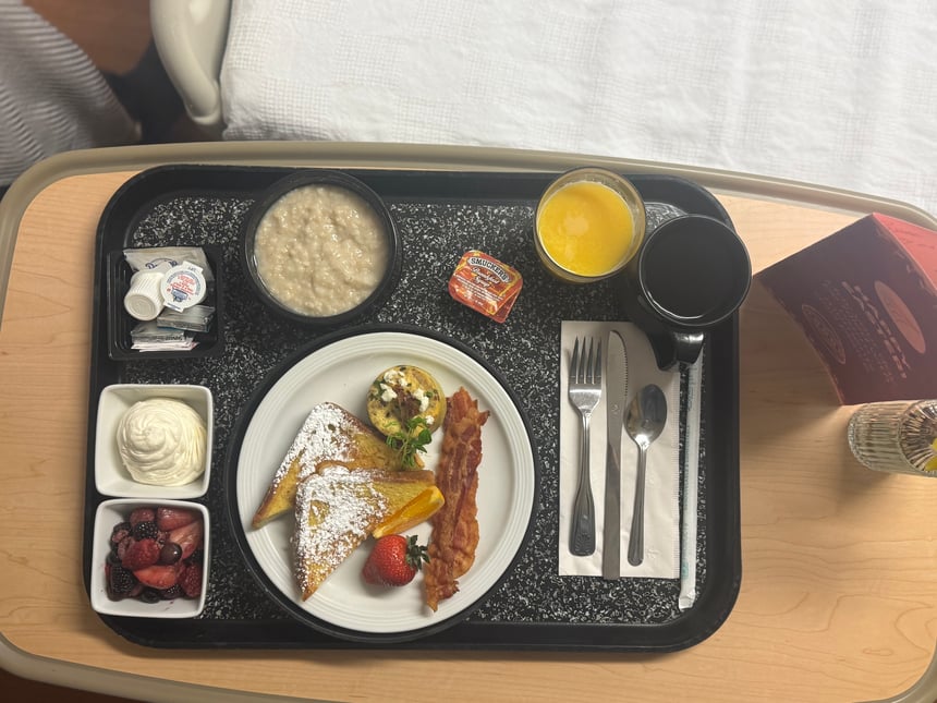 Nutritious hospital breakfast tray served by HHS Culinary Services with fruit, French toast, oatmeal, juice, and coffee.