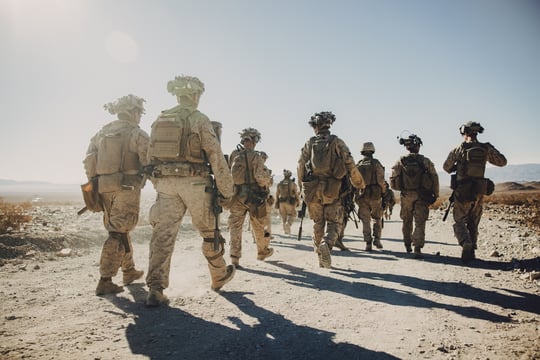 A team of highly skilled military personnel patrols a desert landscape, showcasing leadership, discipline, and tactical expertise. Their experience translates into valuable skills for civilian careers in various industries.