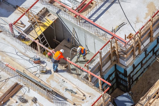 Wide view of active construction site with cranes and equipment operators, illustrating the range of construction roles supported.