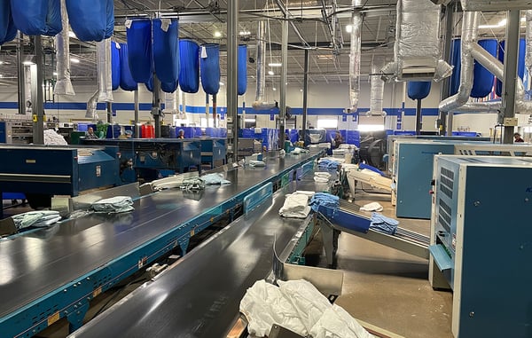 HHS industrial laundry processing facility using automated systems for linen utilization management